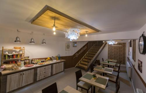 un restaurante con mesas y una escalera en una habitación en Pensiunea Kant, en Sibiu