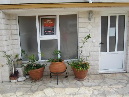 a porch with potted plants in front of a door at Apartments Villa Bella Vista Hvar in Hvar