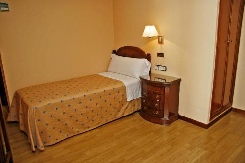 a hotel room with a bed and a desk at Hostal Victoria III in Madrid