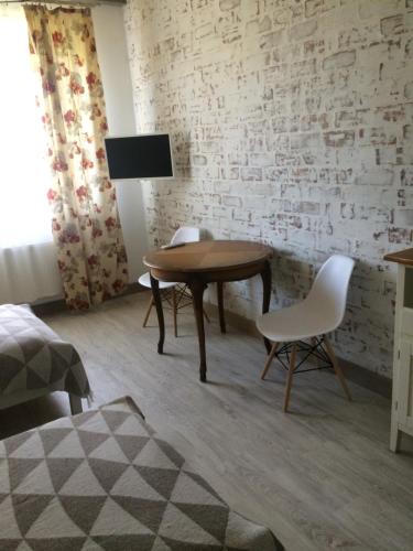 um quarto com uma mesa de madeira e 2 cadeiras em Dzirnaviņas em Biksti