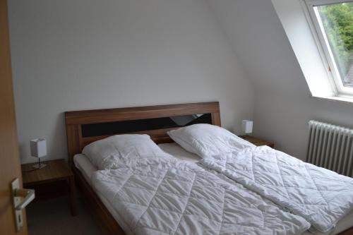 タツィングにあるRochelsand-App-4-OGのベッドルーム1室(白いシーツ付きのベッド1台、窓付)