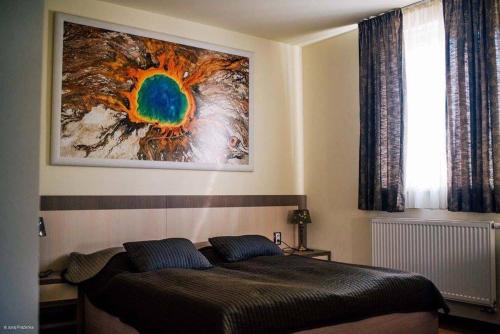 een slaapkamer met een bed met een schilderij aan de muur bij Imet Centrum in Bratislava