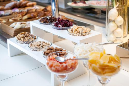 a display case with different types of pastries and desserts at Winter Garden Hotel Bergamo Airport in Grassobbio