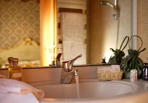 ein Waschbecken mit einem Wasserhahn und einem Spiegel in der Unterkunft Hotel Gorizia a La Valigia in Venedig