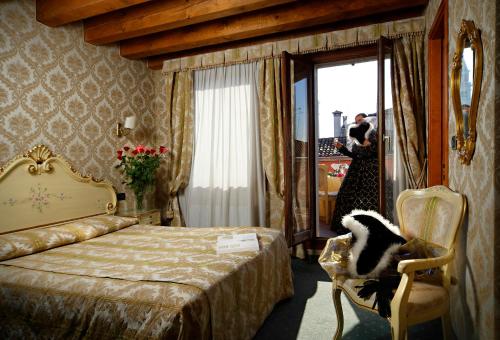 a hotel room with a bed and a person taking a picture at Hotel Gorizia a La Valigia in Venice
