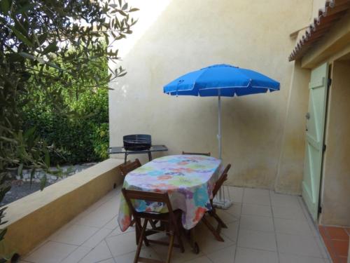 - une table avec un parasol bleu sur la terrasse dans l'établissement La Pitchounette, à La Colle-sur-Loup