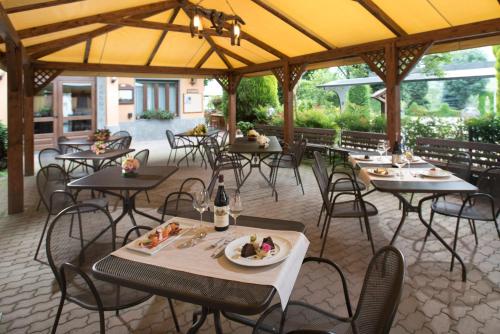 un restaurante con mesas y sillas con comida. en Hotel la Colletta, en Paesana