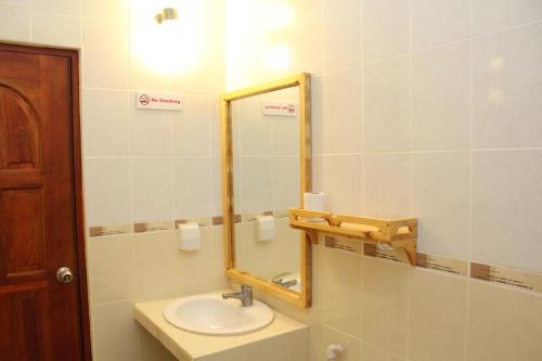 y baño con lavabo y espejo. en Hanifaru Transit Inn en Dharavandhoo