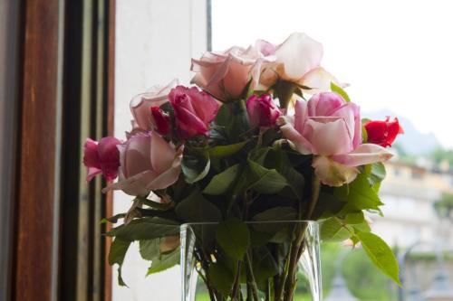 a vase filled with pink roses sitting in a window at Al Vecchio Palazzo in Casto