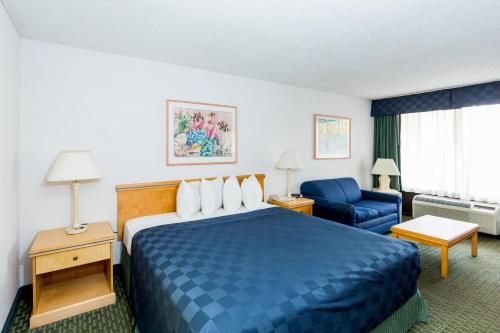 a hotel room with a blue bed and a blue chair at Maingate Lakeside Resort in Orlando