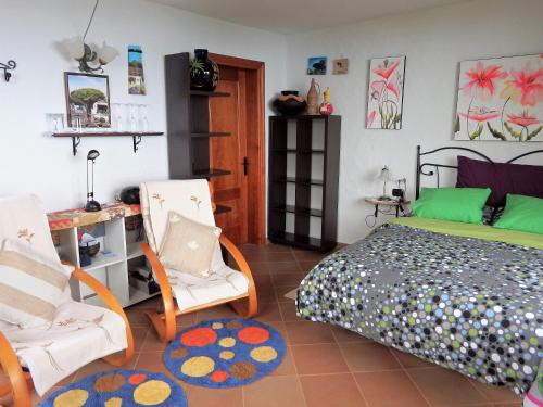 1 Schlafzimmer mit einem Bett und 2 Stühlen in der Unterkunft El Lagar in Icod de los Vinos
