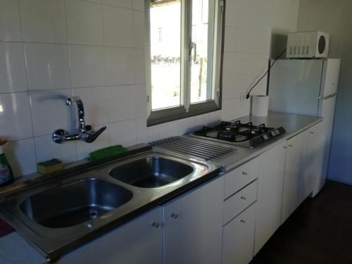 a kitchen with a sink and a stove at Albergue El Paso in Vega de Valcarce