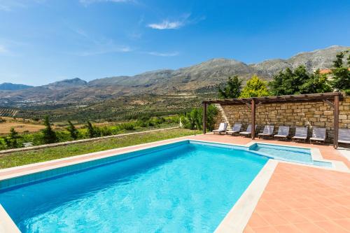 una piscina con montagne sullo sfondo di Thalia Villa, majestic landscape of South Crete, By ThinkVilla a Lefkogeia