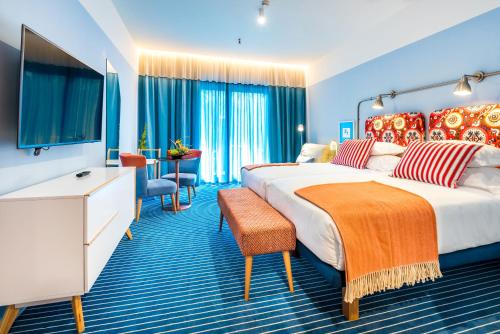 Cette chambre comprend deux lits et une télévision. dans l'établissement Pestana Casino Studios, à Funchal