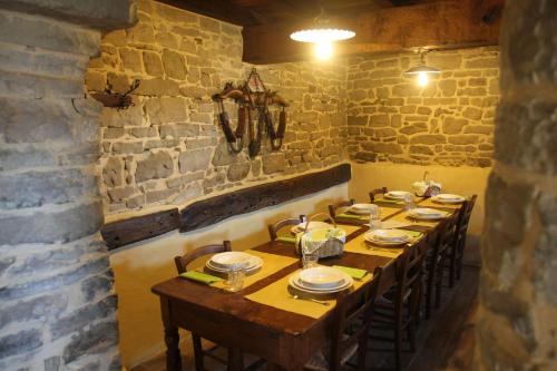 a dining room with a long table in a stone wall at Ca' d'Alfieri in Bardi