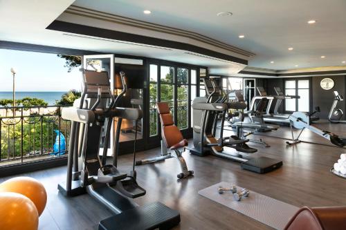 a gym with treadmills and exercise equipment and a large window at Hôtel Barrière L'Hermitage in La Baule