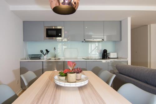 a kitchen and dining room with a wooden table at Casa Castelo 2- Work or Relax in the historic heart of Lisbon! in Lisbon