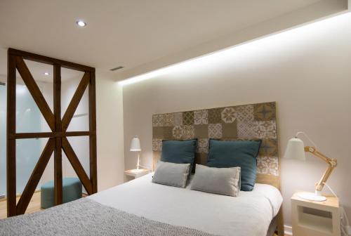 a bedroom with a large bed with blue pillows at Casa Castelo 2- Work or Relax in the historic heart of Lisbon! in Lisbon