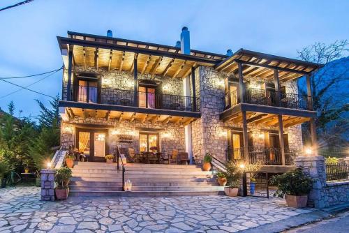 a large house with a staircase in front of it at Asimina Guesthouse, Eptalofos Parnassos in Eptalofos