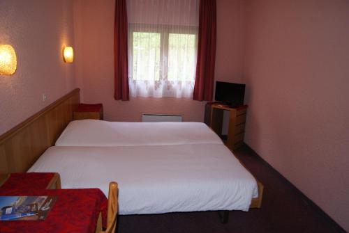 ein Hotelzimmer mit einem Bett und einem Fenster in der Unterkunft Hotel Restaurant du Crêt in Bourg-Saint-Pierre