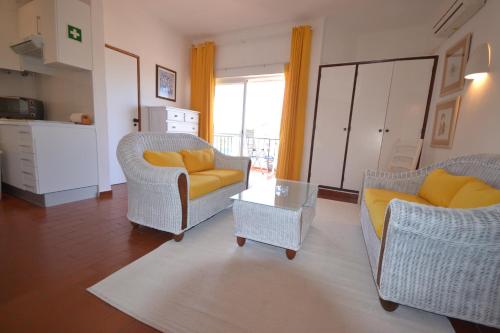 a living room with two chairs and a table at Apartments Miramare Miramonte in Carvoeiro