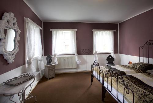 a bedroom with two beds and two windows at Goldberghaus Mauve in Großschönau