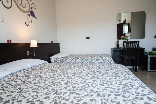 a bedroom with two beds and a table and a chair at Guest House Park in Valmontone