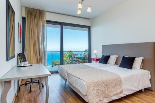 ein Schlafzimmer mit Bett und Blick auf das Meer in der Unterkunft Villa Enjoy - by LovelyStay in Lombo da Velha