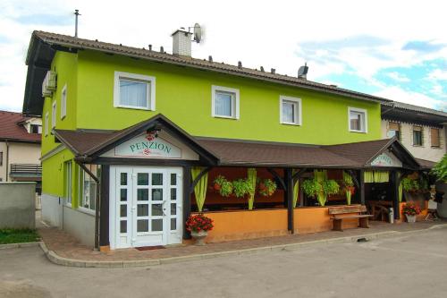una tienda con un edificio verde con una puerta blanca en Penzion Pri Slovenc, en Dol pri Ljubljani