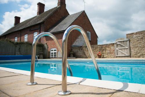 a swimming pool with metal hand rails in front of a house at Paddock Cottage in Newport