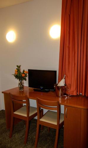 a desk with a computer and two chairs in a room at Penzion Pri Slovenc in Dol pri Ljubljani