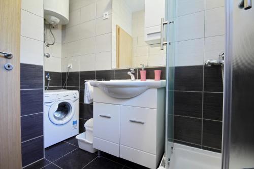 a bathroom with a sink and a washing machine at Vukosav Family Apartments and Rooms in Dubrovnik