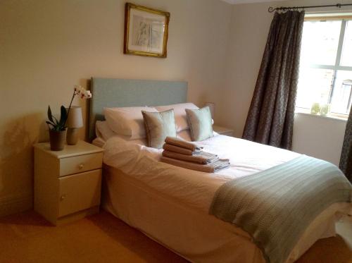 Schlafzimmer mit einem Bett mit weißer Bettwäsche und einem Fenster in der Unterkunft 12 Emperors Wharf in York