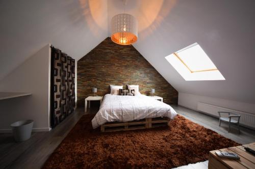 um quarto com uma cama e uma parede de tijolos em Chambres d'Hotes Lorengrain em Bruyères-et-Montbérault