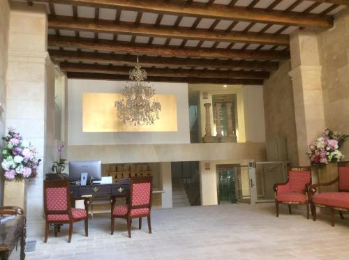 a lobby with a table and chairs and a chandelier at Sindic Hotel - Adults Only in Mahón