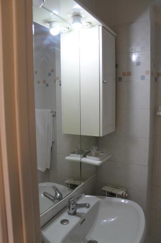 a white bathroom with a sink and a mirror at Vacanze In Torre in Rapolano Terme