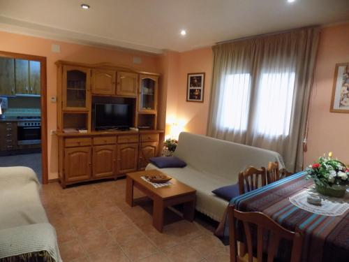 ein Wohnzimmer mit einem Sofa und einem Tisch in der Unterkunft Apartamentos Casa Ferrás in Valderrobres