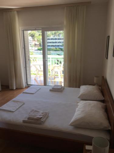 a bedroom with a large bed with a large window at Apartments and rooms Velada in Hvar