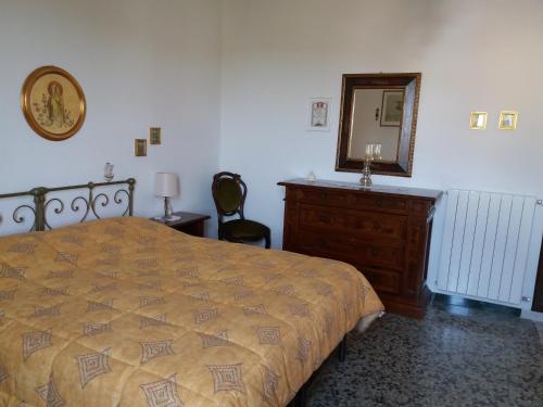 1 dormitorio con cama, tocador y espejo en Sa Nuche, en Mamoiada