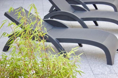 a group of chairs sitting next to a bush at Hotel Ostermann in Treis-Karden