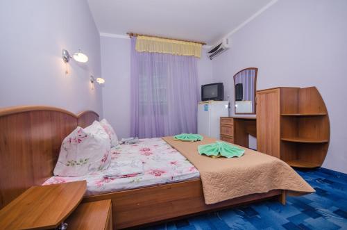 a bedroom with a bed with two towels on it at Sedmoye Nebo Hotel in Utes