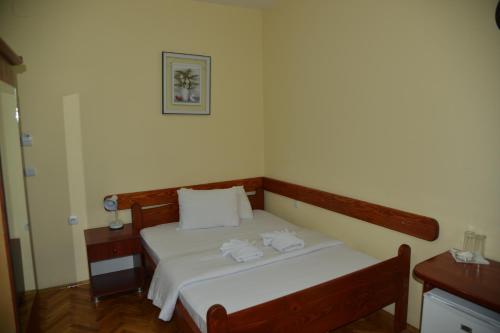 a bedroom with a bed with two towels on it at Hotel Bella Donna in Kumanovo