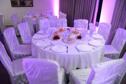 a table with white chairs and a white table cloth at Hotel Bella Donna in Kumanovo