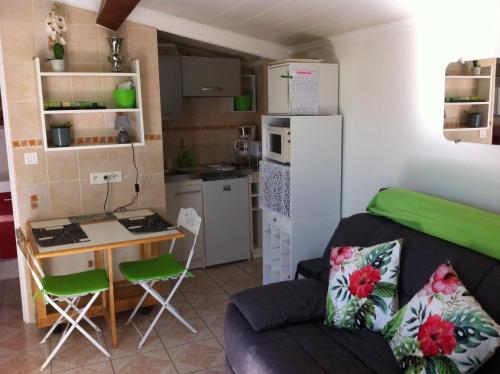ラ・シオタにあるcharmant studio proche merのリビングルーム(ソファ付)、小さなキッチンが備わります。