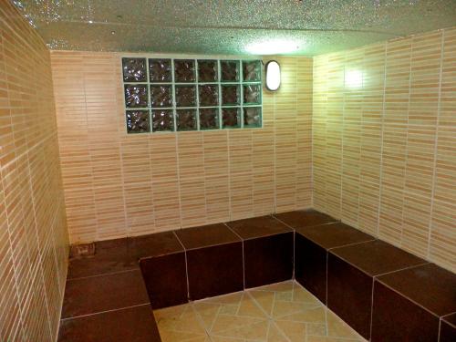 a corner of a room with brown tile and a window at Hostal Sauna Tambo Wasi in Huancayo