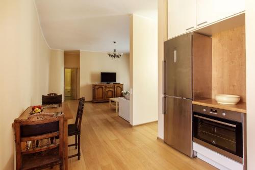 a kitchen with a table and a stainless steel refrigerator at Luxurious and Stylish Old Town Apartment in Vilnius