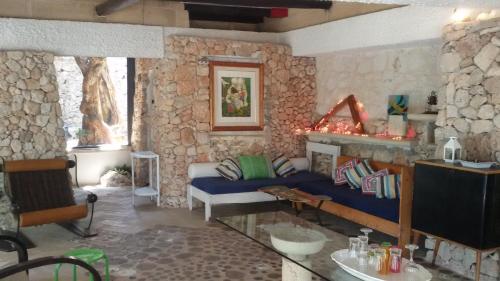 a living room with a couch and a stone wall at Limonaia in Salento in Marittima