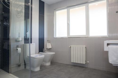 a bathroom with a toilet and a shower and a window at Hostal Real Aranjuez in Aranjuez