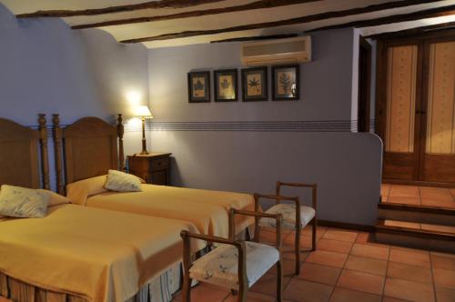 a room with two beds and chairs in it at Hotel la Casa del Abuelo in Albarracín