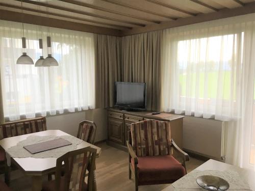 a living room with a table and a television at Appartements Michaela in Westendorf